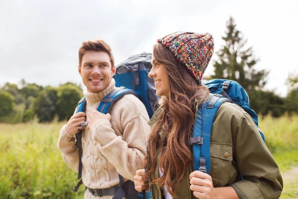 Lachende paar met rugzakken wandelen — Stockfoto