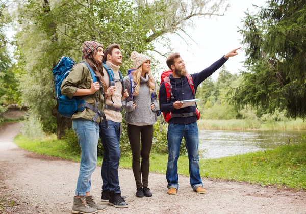 Grupo de amigos sonrientes con mochilas senderismo —  Fotos de Stock