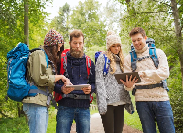 Groep vrienden met rugzakken en tablet pc — Stockfoto