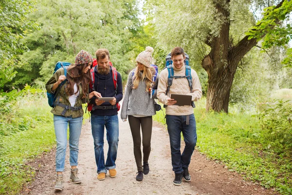 Grupo de amigos com mochilas e tablet pc — Fotografia de Stock