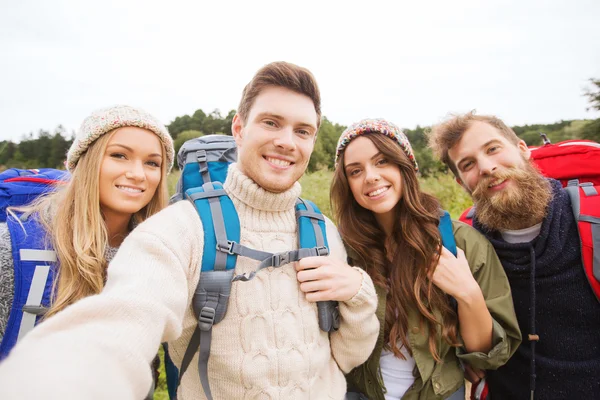 Grupo de amigos sonrientes con mochilas senderismo —  Fotos de Stock