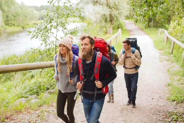 Group of smiling friends with backpacks hiking — Stock Photo, Image