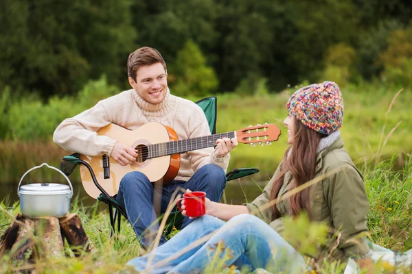 Smiling couple with guitar in camping — Stock Photo, Image