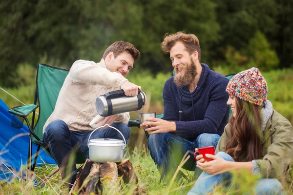 Group of smiling friends cooking food outdoors — Stock Photo, Image