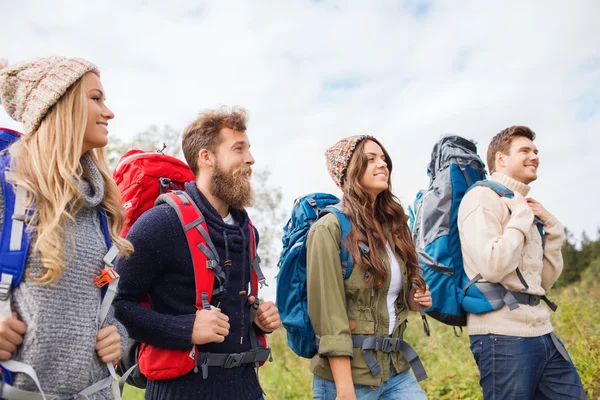 Gruppe smilende venner med ryggsekkturgåere stockfoto