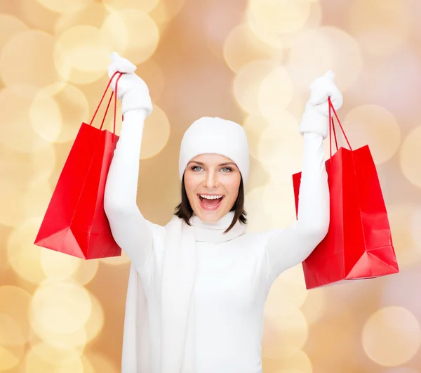 Sorrindo jovem mulher com sacos de compras vermelhos — Fotografia de Stock