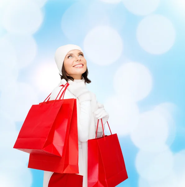 Sorrindo jovem mulher com sacos de compras vermelhos — Fotografia de Stock