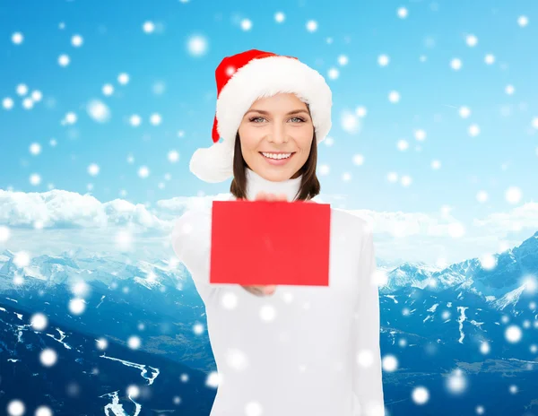 Frau mit Weihnachtsmann-Helfermütze mit leerer roter Karte — Stockfoto