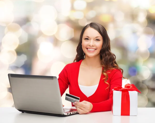 Mulher sorridente com cartão de crédito e laptop — Fotografia de Stock