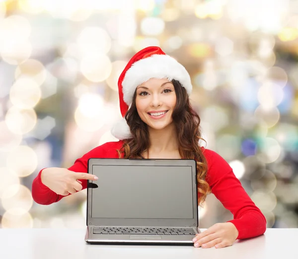 Mulher sorridente em santa chapéu ajudante com laptop — Fotografia de Stock