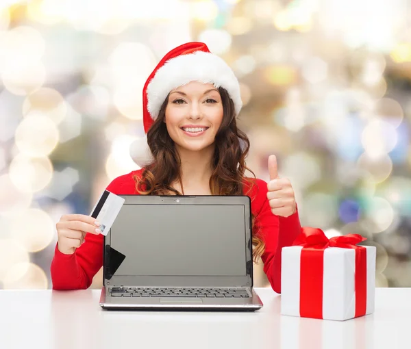 Mulher sorridente com cartão de crédito e laptop — Fotografia de Stock