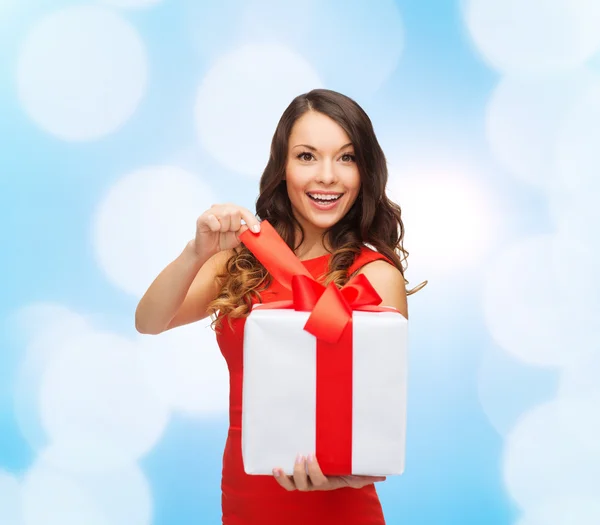 Lachende vrouw in rode jurk met geschenkdozen — Stockfoto