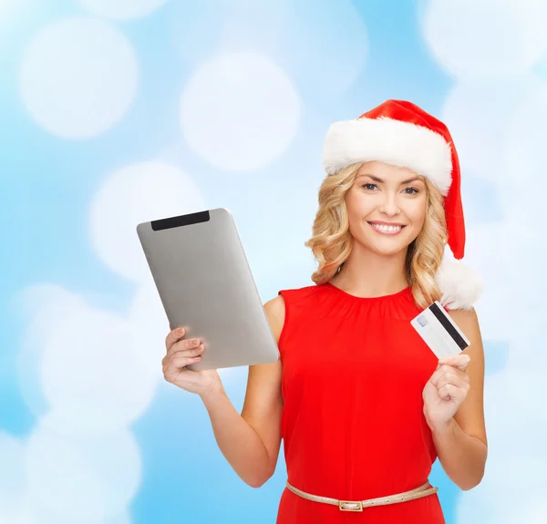 圣诞老人的帽子与 tablet pc 和信用卡的女人 — 图库照片
