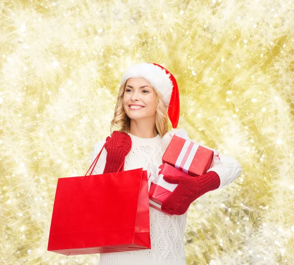 Lächelnde junge Frau im Weihnachtsmann-Helferhut mit Geschenken — Stockfoto
