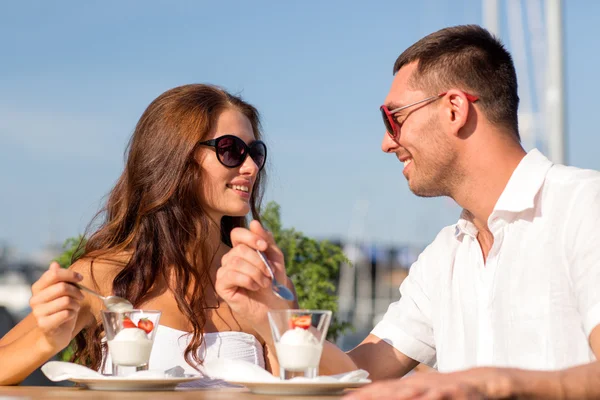 Smiling couple eating dessert at cafe — Stock Photo, Image