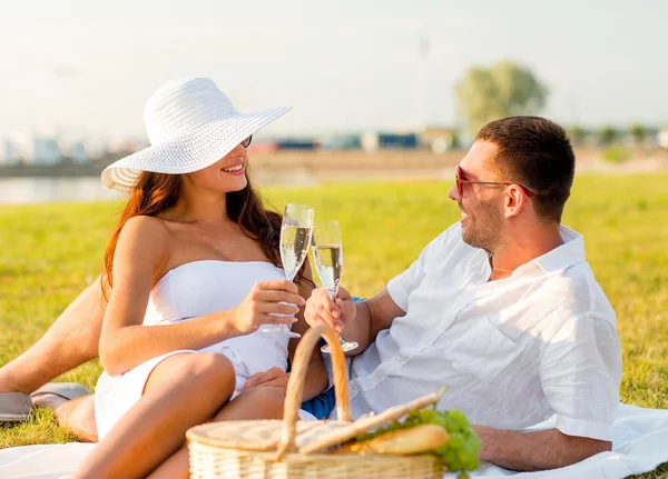 Sonriente pareja bebiendo champán en el picnic —  Fotos de Stock