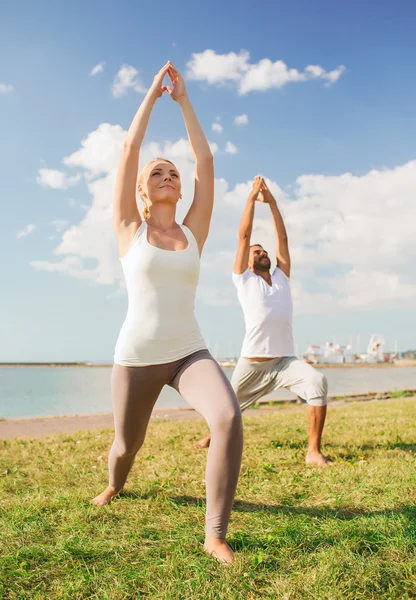 Par gör yogaövningar utomhus — Stockfoto