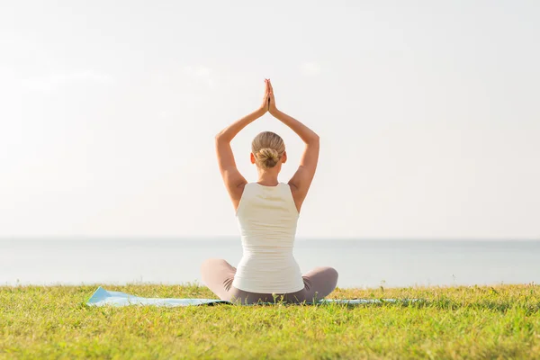 Vrouw het maken van yoga oefeningen buiten — Stockfoto