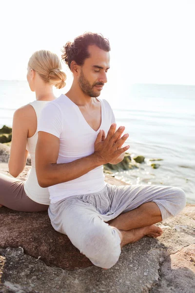Улыбающаяся пара делает упражнения для йоги на открытом воздухе — стоковое фото