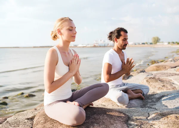 Lächelndes Paar macht Yoga-Übungen im Freien — Stockfoto