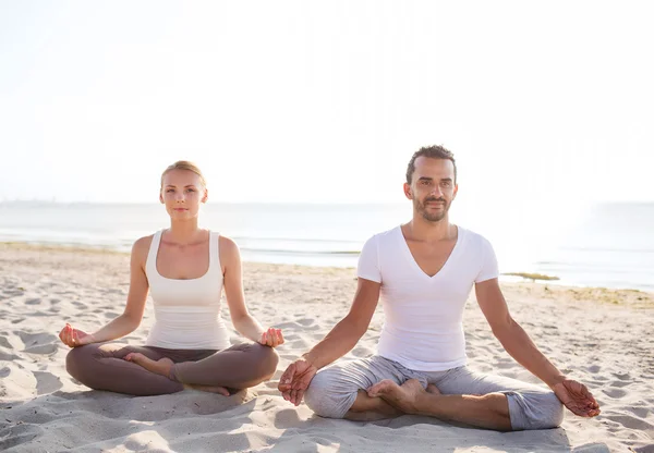 Çift gülümseyen açık havada yapım yoga egzersizleri — Stok fotoğraf