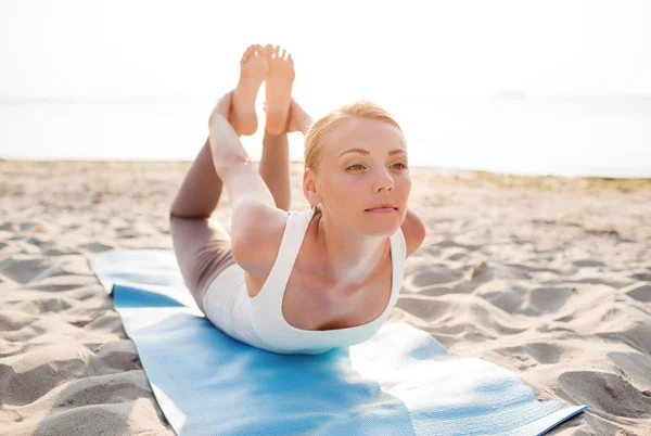 Mujer joven haciendo ejercicios de yoga al aire libre — Foto de Stock