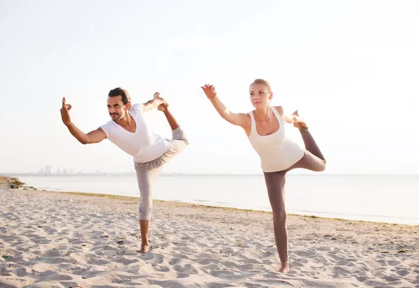 Par gör yogaövningar utomhus — Stockfoto