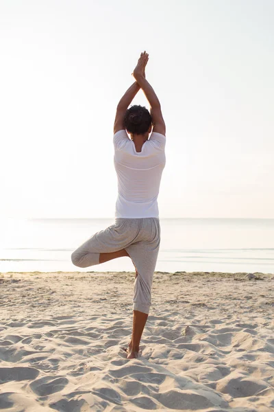 Hombre haciendo ejercicios de yoga al aire libre desde atrás — Foto de Stock