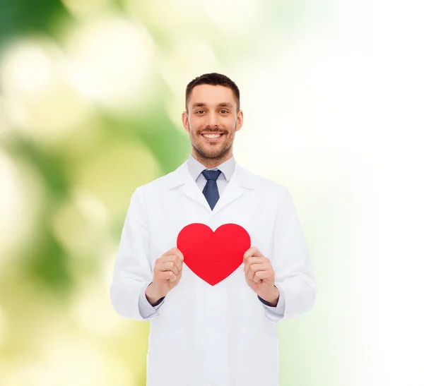 Sonriente médico varón con corazón rojo — Foto de Stock