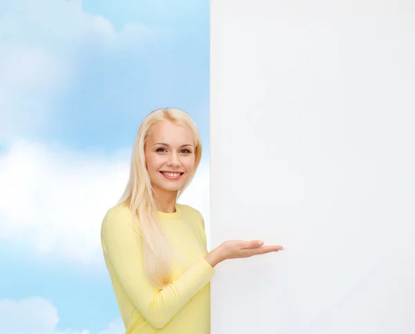 Usmívající se žena ve svetru s prázdnou bílou tabuli — Stock fotografie