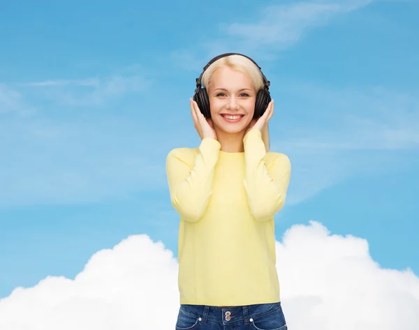 Leende ung kvinna med hörlurar — Stockfoto