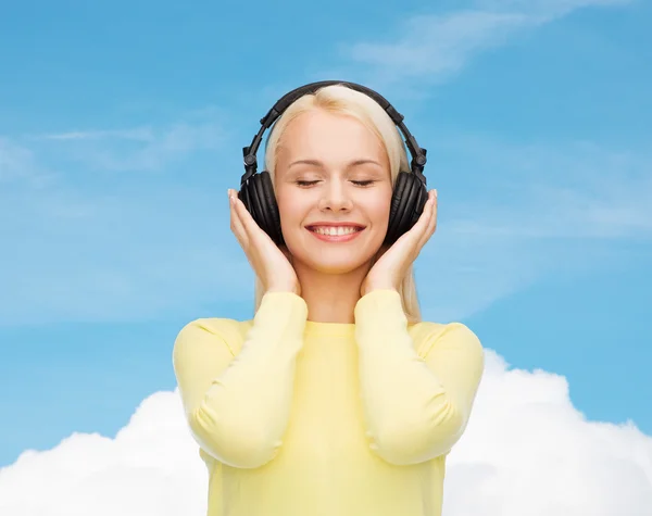Usmívající se mladá žena se sluchátky — Stock fotografie