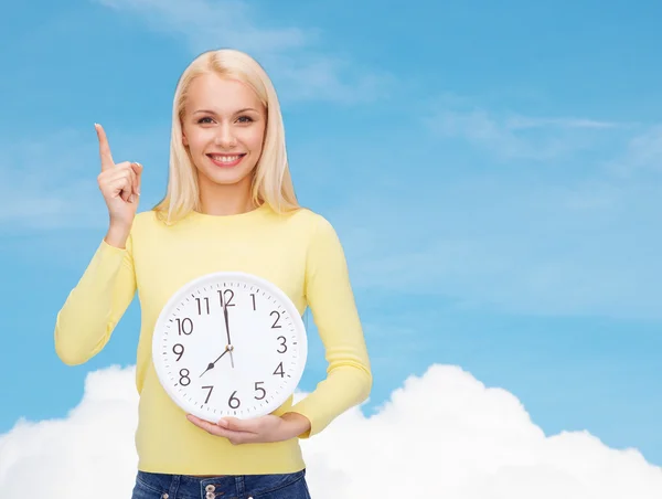 Student med väggklocka och finger upp — Stockfoto