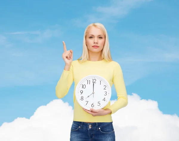 Étudiant avec horloge murale et doigt levé — Photo