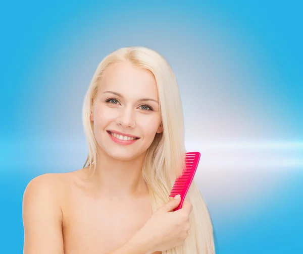 Donna sorridente con spazzola per capelli — Foto Stock