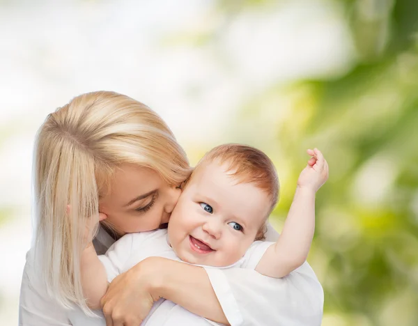 Mãe feliz beijando bebê sorridente — Fotografia de Stock