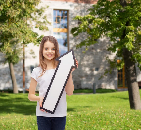 Smiling little girl with blank arrow pointing up — Stock Photo, Image