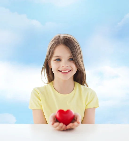 Belle petite fille assise à table — Photo