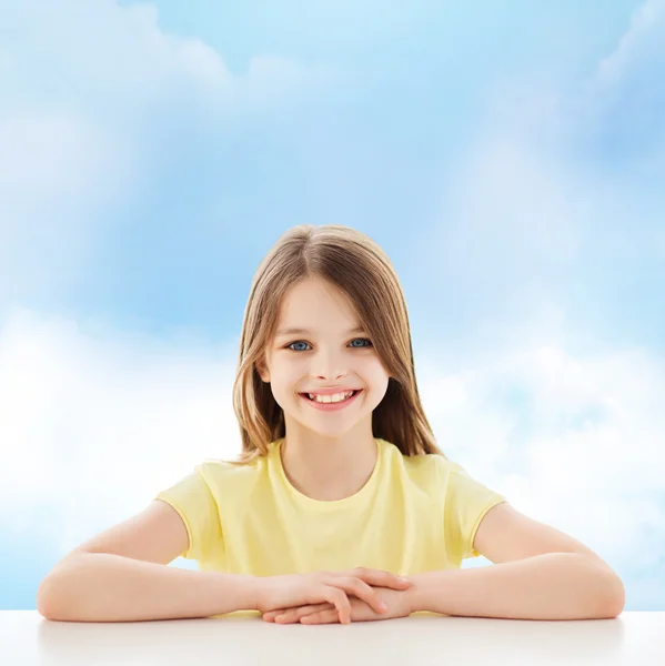 Schönes kleines Mädchen am Tisch sitzend — Stockfoto