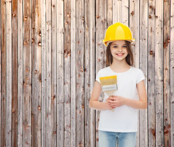 Smiling little girl in helmet with paint brush — Stock Photo, Image