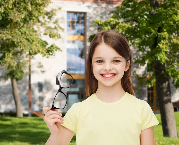 Usmívající se roztomilá holčička drží černé brýle — Stock fotografie