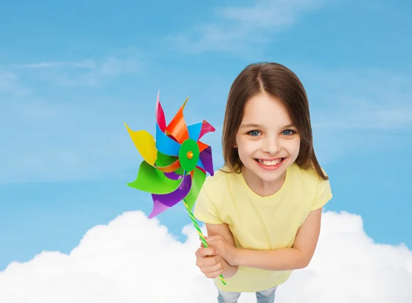 Criança sorridente com brinquedo colorido de moinho de vento — Fotografia de Stock