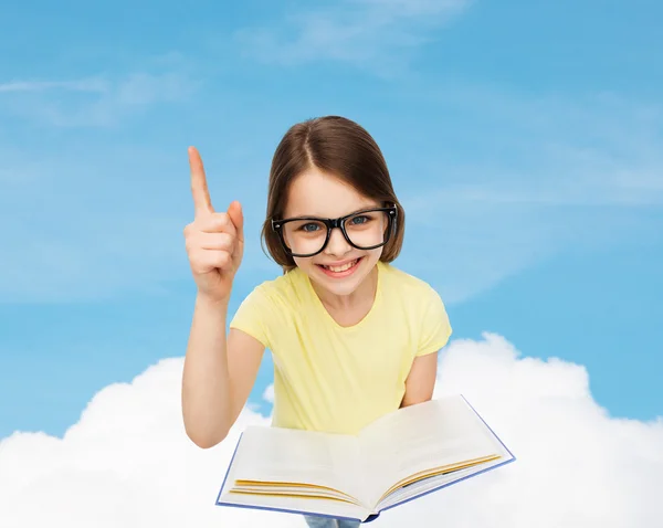 Улыбающаяся маленькая девочка в очках с книгой — стоковое фото