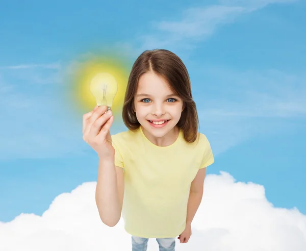 Smiling little girl holding light bulb — Stock Photo, Image
