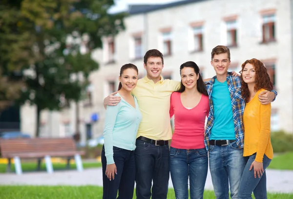 Grupo de adolescentes sonrientes sobre el fondo del campus —  Fotos de Stock