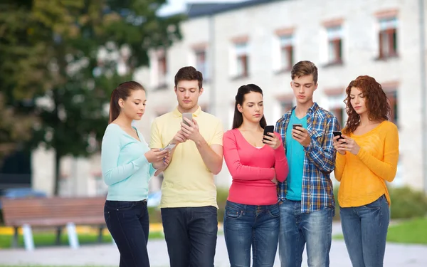 Grupo de adolescentes graves com smartphones — Fotografia de Stock
