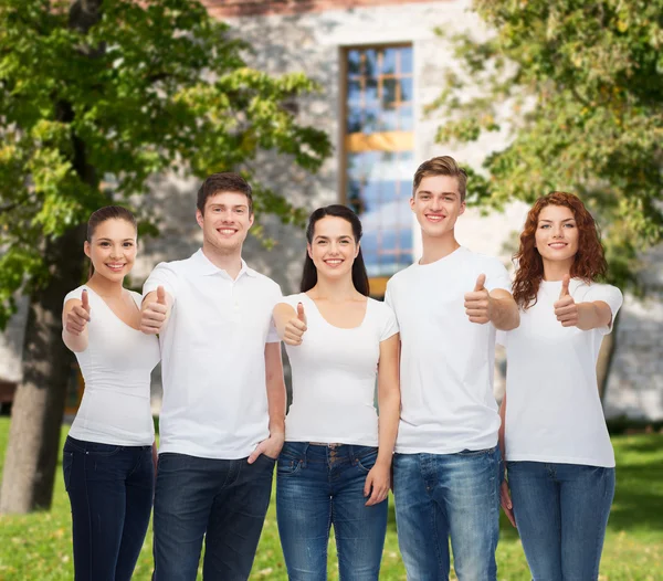 Adolescentes sonrientes en camisetas mostrando los pulgares hacia arriba — Foto de Stock