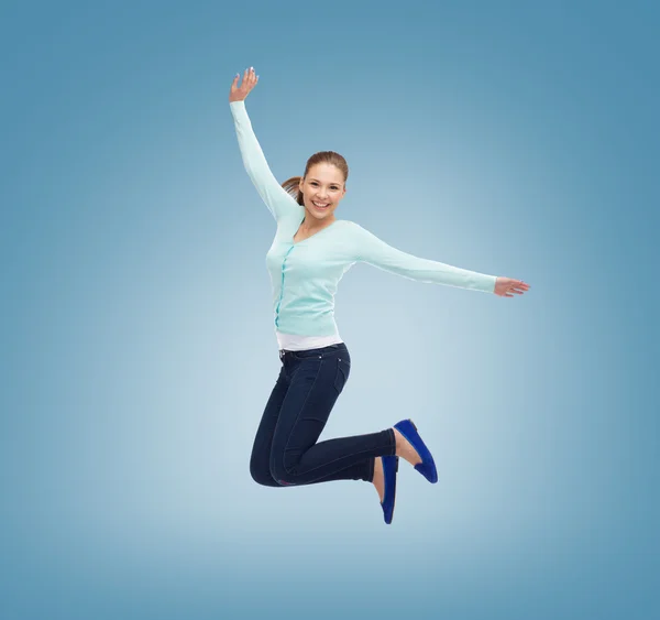 Lachende jonge vrouw springen in de lucht — Stockfoto