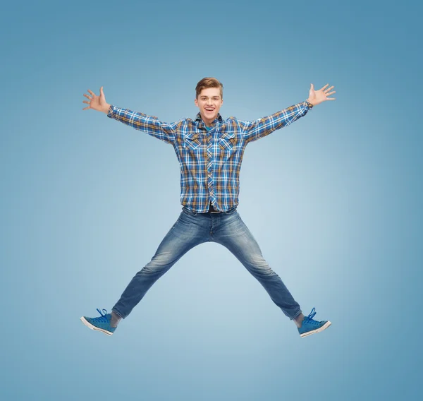 Smiling young man jumping in air — Stock Photo, Image