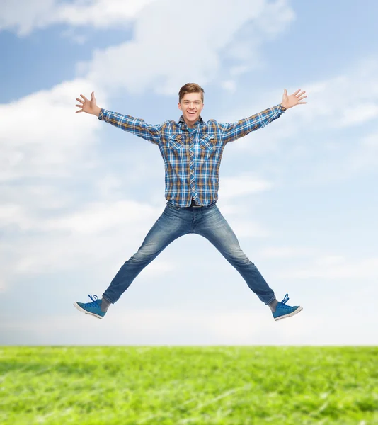 Lachende jonge man springen in de lucht — Stockfoto